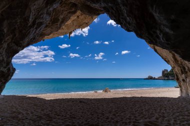 Sardunya 'da mavi gökyüzünün altında deniz olan kayalık plajın güzel manzarası.