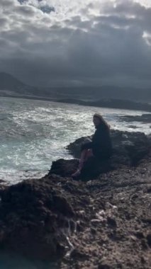 Denizle plajda dinlenen kadın.