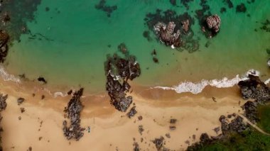 Sahilin tepesinden bir sürü dalga ve kayalık bir manzara..