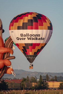 Hamilton, Yeni Zelanda, 14 Mart 2023: Şafakta Waikato üzerinde balonlar, gölün karşısından manzara