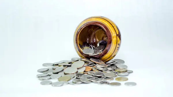 İçinde bozuk para olan bir sürü Tayland baht sikkesi ve kil kavanozu. Beyaz arkaplan izole