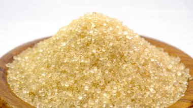 Tahta bir kabın içinde kahverengi şekerin yakın plan görüntüsü. Baharatlı yiyecekler için. Beyaz arka plan. İzole edilmiş.