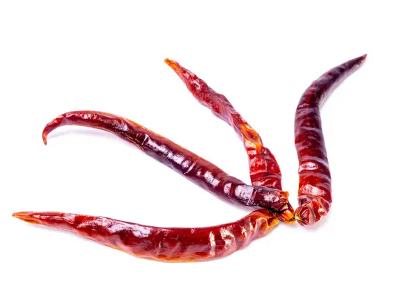 Görüntü, beyaz arka planda sıralanmış dört kurutulmuş kırmızı biber sergiliyor. Her bir biber uzun ve incedir. Kahverengimsi kırmızıdan kahverengiye kadar koyu kırmızı bir teni vardır. Bu da baharatını gösterir. Bu kurutulmuş biberler genellikle çeşitli malzemelerde kullanılır. 