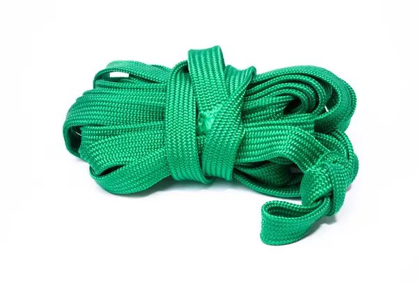 Beyaz arka planda izole edilmiş yeşil bir halat sarmalı. İp sentetik bir maddeden yapılmış gibi görünüyor ve pürüzsüz ve tutarlı bir dokusu var..