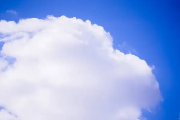 Açık mavi gökyüzüne doğru ilerleyen tüylü bulutların görüntüsü. Bulutlar, aydınlık ve güneşli bir günde doğanın güzelliğini yakalamak için mükemmel sakin ve resimsel bir sahne yaratırlar..