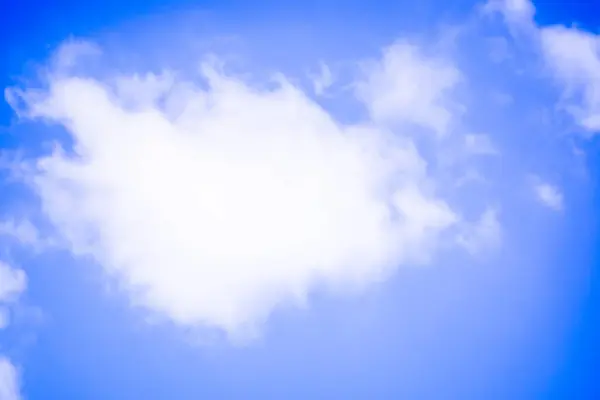 Rüzgarla savrulan beyaz kabarık bulutları gösteren bir görüntü güzel mavi bir gökyüzü zeminine karşı. Dinamik hareket ve canlı renkler, doğa aşıkları için mükemmel, huzurlu ve resimsel bir sahne yaratır..