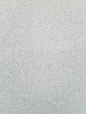 Kabataslak, desenli yüzeyi olan beyaz bir duvarın yakın plan görüntüsü. Duvarın dokusu, çeşitli tasarım projeleri için ilginç ve çok yönlü bir zemin oluşturan küçük çıkıntılar ve girintiler oluşturur..