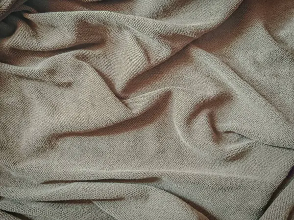 Yumuşak, buruşuk yüzeyi, tasarım, tekstil veya kırsal dekor temaları için ideal bej kumaşın dokulu bir arka planı. 