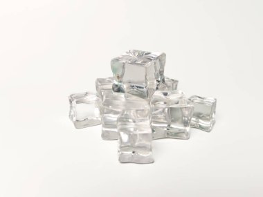 Beyaz arka planda küçük ve büyük şeffaf buz küpleri koleksiyonu. Bu küpler izole edilmiş, berraklık ve temiz estetiklerini sergiliyorlar, ferahlatıcı veya serinletici temaları temsil etmek için ideal..