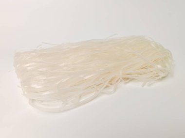 İnce ve şeffaf Korat erişteleri temiz ve izole edilmiş beyaz arka plana karşı düzgünce dizilmiş. Otantik Tayland mutfağının temel ihtiyaçlarının mükemmel bir temsili..