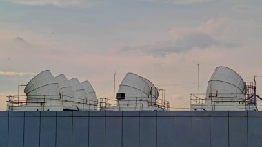 Fabrikalarda ısı değişimi için hayati önem taşıyan büyük endüstriyel soğutma kulelerinin fotoğrafı. Endüstriyel verimliliği vurgulayarak, bu yapıların ölçeği ve işlevselliğini yakalar