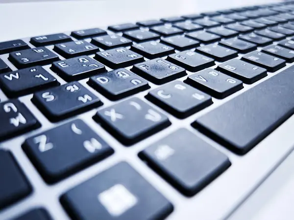 İngilizce ve Taylandlı karakterlerin yer aldığı iki dilli bir klavyenin detaylı bir yakın çekimi. Açık anahtar düzenlemesi çok dilli kullanıcılar için erişilebilirlik ve kolaylığı arttırır