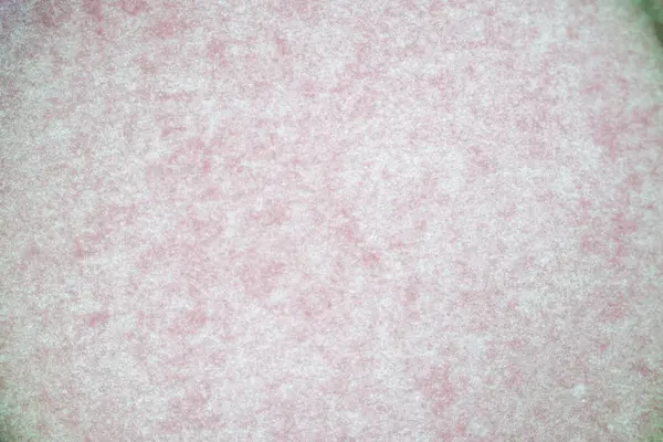 Görünür dokusu ve ince desenleri olan yumuşak pembe kağıdın makro soyut görüntüsü. Arkaplan, kırtasiye tasarımı, pastel temalar veya minimalist görsel içerik için ideal.