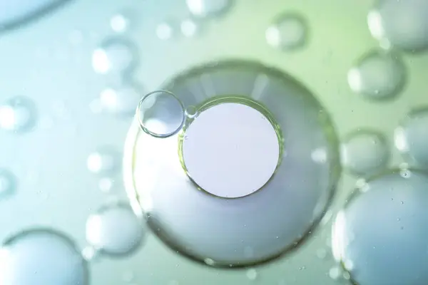 Kremsi dokuya sahip soyut yağ ve su kabarcıkları, sıvı etkileşimi ve yumuşak eğimleri vurguluyor. Güzellik, bilim veya minimalist tasarım temaları için ideal.