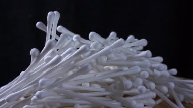 Beyaz pamuk tomurcuklarının tahta bir zeminde girdap oluşturduğu, koyu bir arka planda geçen makro bir video. Yumuşak doku ve hareket, temiz ve minimalist bir estetik yaratır..