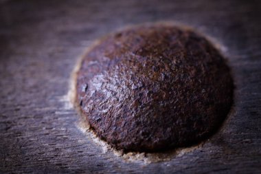 Eski ahşabın içine gömülü paslı bir vidanın makro çekimi, desen, çürüme ve endüstriyel giysi sergiliyor. Soyut arkaplan ve tasarım ögeleri için ideal.