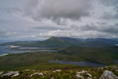 İrlanda dağları, bulutların yürüdüğü tarlalar tarafından sindirilmişti. Yüksek kalite fotoğraf