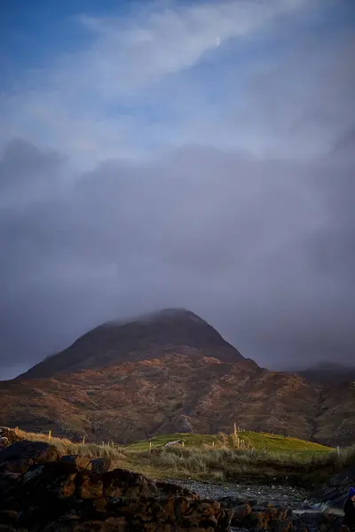 İrlanda dağları, bulutların yürüdüğü tarlalar tarafından sindirilmişti. Yüksek kalite fotoğraf