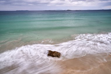 Kaya bulutlu bir günde plaj dalgalarına uzun süre maruz kalmak. Yüksek kalite fotoğraf