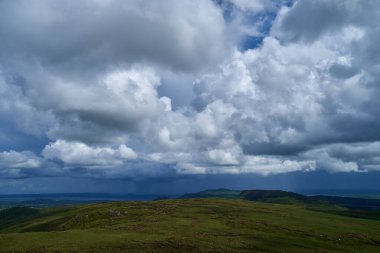 Cumulus or cluster clouds moving over a field with blue sky background in sunny weather in a wide angle shot. High quality photo clipart