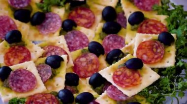 Doğranmış antipasto eti masada yavaşça döner. Siyah bir arka planda. projeniz için video.