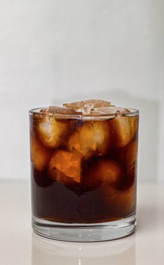 Buzlu soğuk kahve, beyaz arka planda berrak bir fincanda.