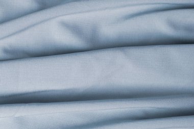 Açık mavi soyut arkaplan ve mat saten desenli. Doku arkaplanı için dalgalı saten