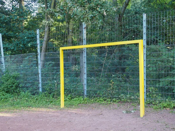 Yellow handball goal on a rotten sports field
