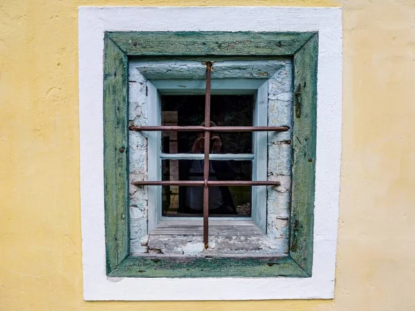 an old window with a green wall.