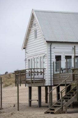 Beach house on stilts by the sea clipart