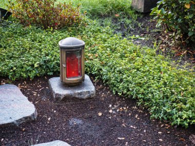 Grave decoration with candle and flowers