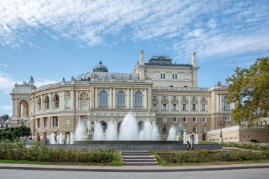 Odesa, Ukrayna - 30 Eylül 2023 Odesa 'da sonbahar günü, sıcak güneşli hava. Savaş sırasında izinli bir günde, insanlar tiyatronun yakınında yürürler. Odesa Ulusal Opera ve Bale Akademik Tiyatrosu, mimari dönüm noktası, Ukrayna.