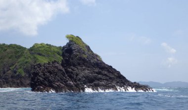 Çok egzotik ve şaşırtıcı. Pelerinin şekli kayalık bir tepe. Mavi gökyüzü ve deniz manzaralı birkaç ağaçla kaplı..
