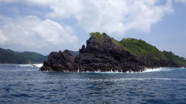 Çok egzotik ve şaşırtıcı. Pelerinin şekli kayalık bir tepe. Mavi gökyüzü ve deniz manzaralı birkaç ağaçla kaplı..