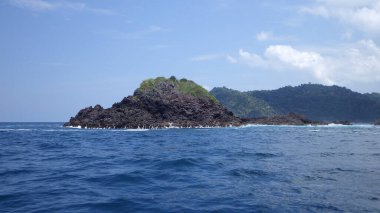 Çok egzotik ve şaşırtıcı. Pelerinin şekli kayalık bir tepe. Mavi gökyüzü ve deniz manzaralı birkaç ağaçla kaplı..