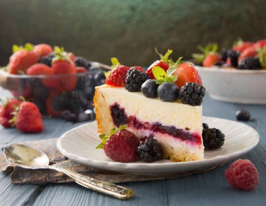 Üstünde çilek ve yaban mersini olan bir dilim pasta.