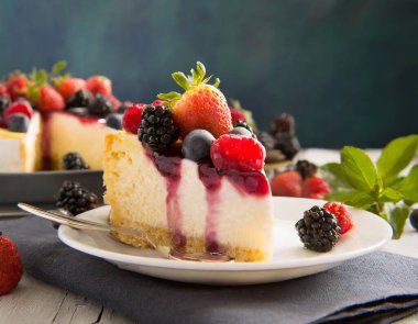 Üstünde çilek ve yaban mersini olan bir dilim pasta.