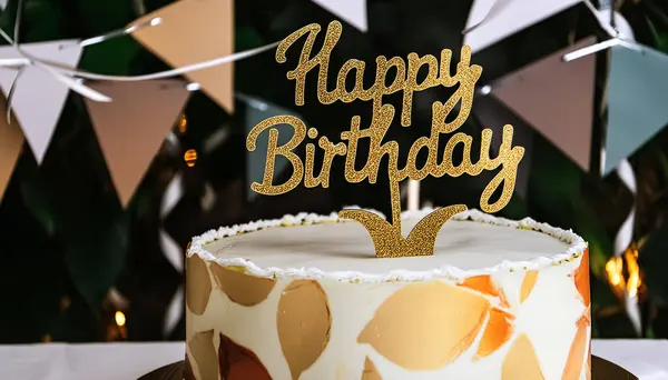 Doğum günü mesajı olan altın bir pankart doğum günü pastasını süslüyor.