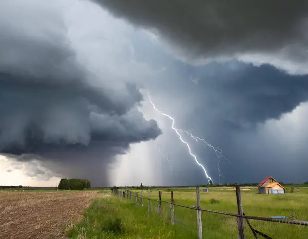 Fırtınalı bir gökyüzü ve arka planda birkaç ev.