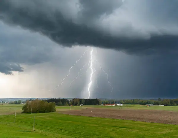 Fırtınalı bir gökyüzü ve arka planda birkaç ev.