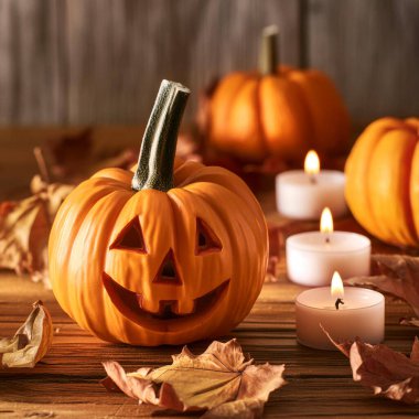 Balkabağı mumu ahşap masa dekorasyonu Sonbahar yapraklarıyla Cadılar Bayramı için