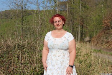 Ormanda güzel bir sonbahar gününde kızıl saçlı mutlu bir kadının portresi.