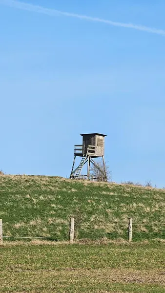İlkbaharda kırsaldaki tepede av kulesi.