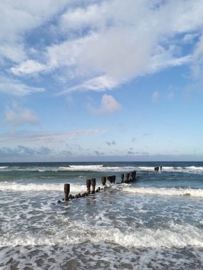 Baltık Denizi kıyısında Rostock (Almanya) kenti yakınlarında dalgalar ve damızlıklar)