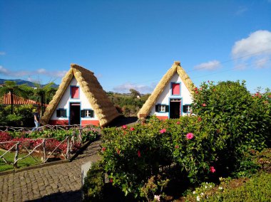 a tourist-themed park with old houses  in the village of Santana (Madeira, Portugal) clipart