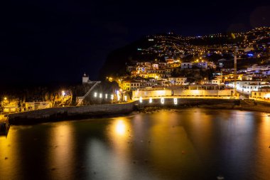 Portekiz 'in Madeira adasındaki Camara de Lobos balıkçı köyünün gece çekimi.