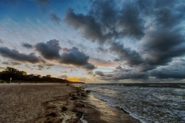 Warnemnde 'deki Baltık Denizi plajında gün batımında dramatik bir gökyüzü (Rostock, Almanya)