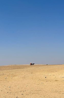 Büyük kum tepeleri ve mavi gökyüzü olan çöl, küçük araba, Kahire, Mısır