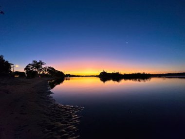 Bir nehrin üzerinde güzel bir günbatımı, Günışığı Sahili, Queensland, Avustralya