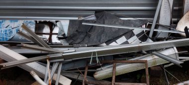 Bir dış mekanda atılmış metal borular, kablolar ve diğer inşaat malzemeleri yığını..